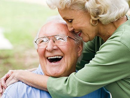 A woman hugging a smiling man.